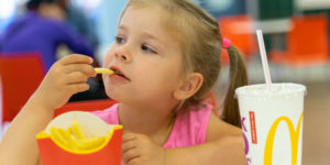 young-girl-eating-french-fries-at-mcdonalds